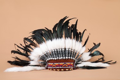 Photo of Traditional warbonnet (Native American chief headdress) on beige background