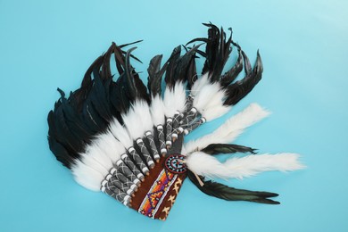 Photo of Traditional warbonnet (Native American chief headdress) on light blue background, top view