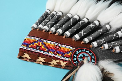 Photo of Traditional warbonnet (Native American chief headdress) on light blue background, closeup