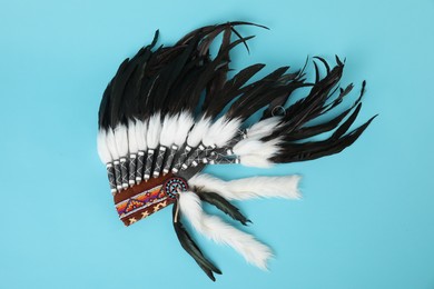 Photo of Traditional warbonnet (Native American chief headdress) on light blue background, top view