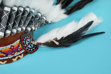 Photo of Traditional warbonnet (Native American chief headdress) on light blue background, closeup