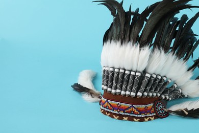 Photo of Traditional warbonnet (Native American chief headdress) on light blue background, space for text