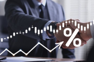 Image of Business partners shaking hands, closeup. Percent sign, arrow and graph