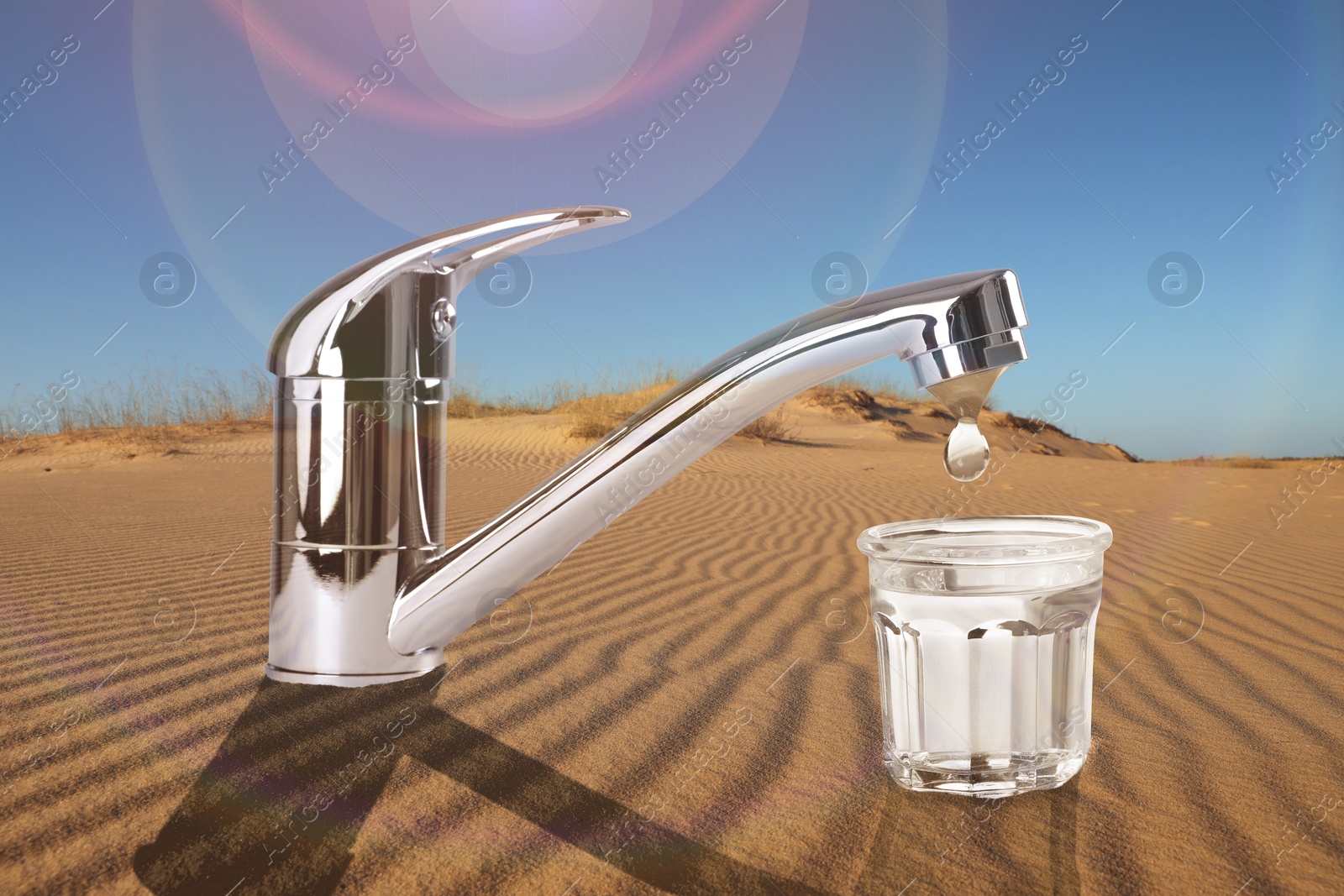 Image of Save water concept. Glass under tap with dripping water in desert