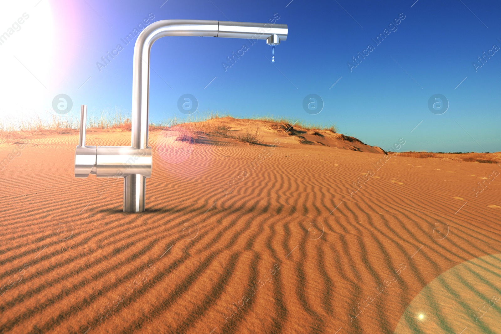 Image of Save water concept. Tap with dripping water in desert under scorching sun