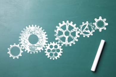 Image of Many cogwheels drawn on green chalkboard, top view. Gear mechanism