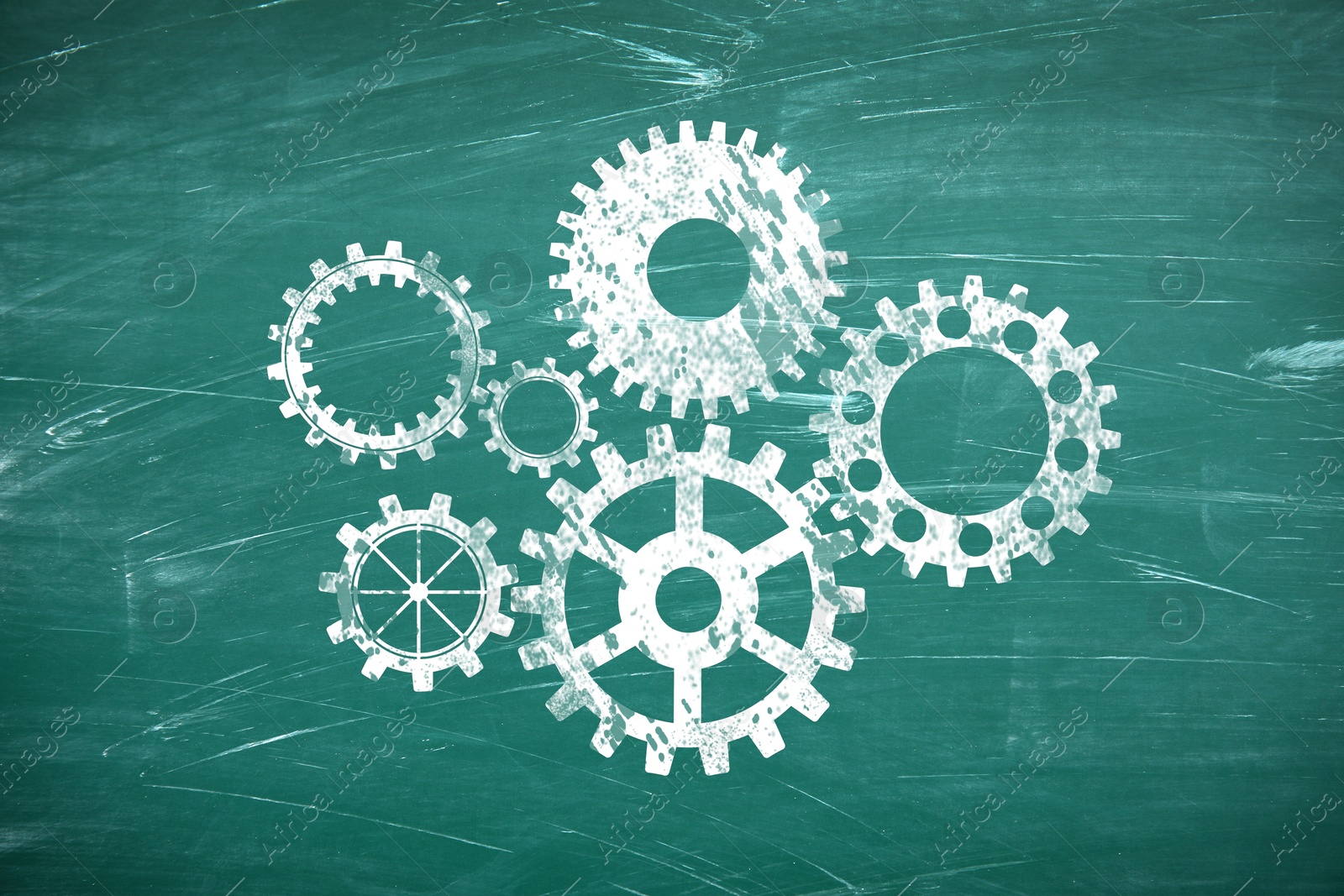 Image of Many cogwheels drawn on green chalkboard. Gear mechanism