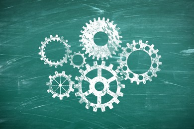 Image of Many cogwheels drawn on green chalkboard. Gear mechanism