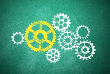 Image of Many cogwheels drawn on green chalkboard. Gear mechanism