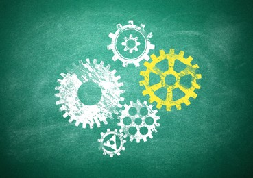 Image of Many cogwheels drawn on green chalkboard. Gear mechanism