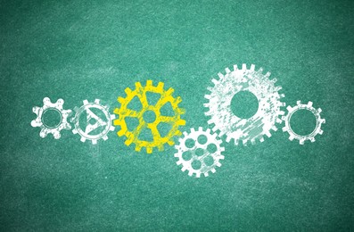 Image of Many cogwheels drawn on green chalkboard. Gear mechanism