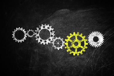 Image of Many cogwheels drawn on black chalkboard. Gear mechanism