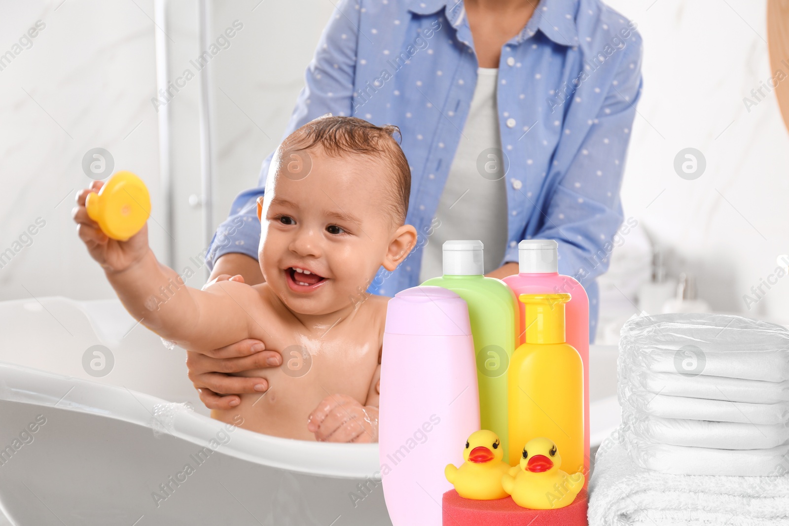 Image of Mother with her little baby, accessories and toiletries in bathroom