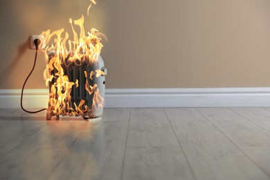 Image of Burning heater in room, flames all over device. Do not leave unattended. Dangerous accident