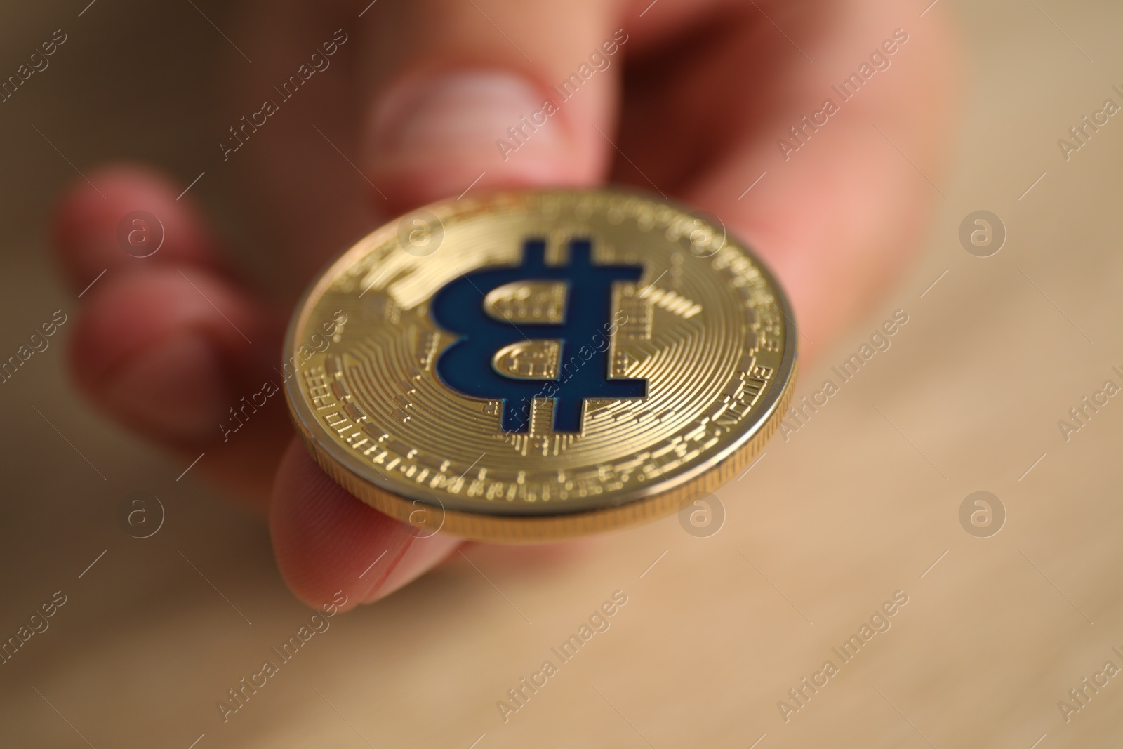 Photo of Cryptocurrency. Man with golden bitcoin at table, closeup