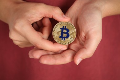 Photo of Cryptocurrency. Man with golden bitcoin on red background, closeup