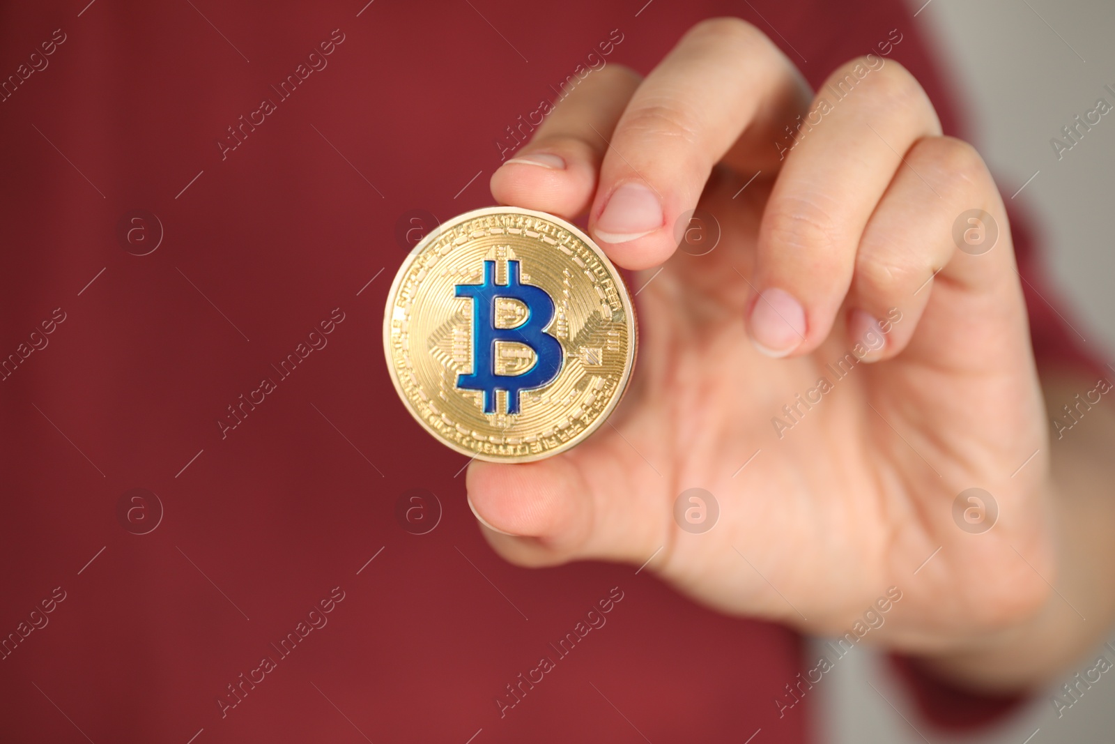 Photo of Cryptocurrency. Man with golden bitcoin on grey background, closeup. Space for text