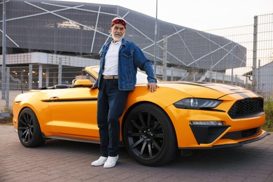 Photo of Stylish senior man near modern cabriolet outdoors