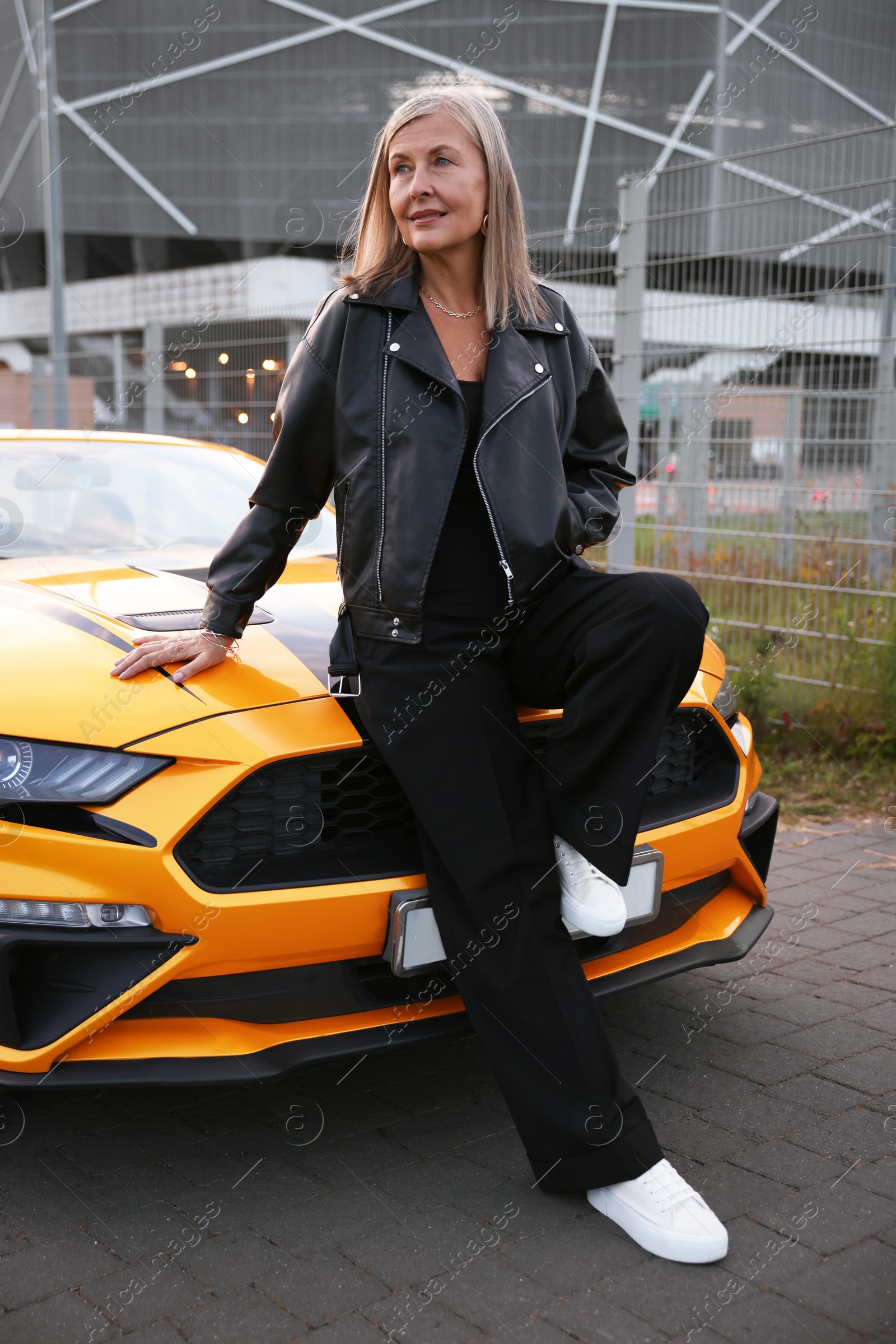 Photo of Stylish senior woman near modern cabriolet outdoors