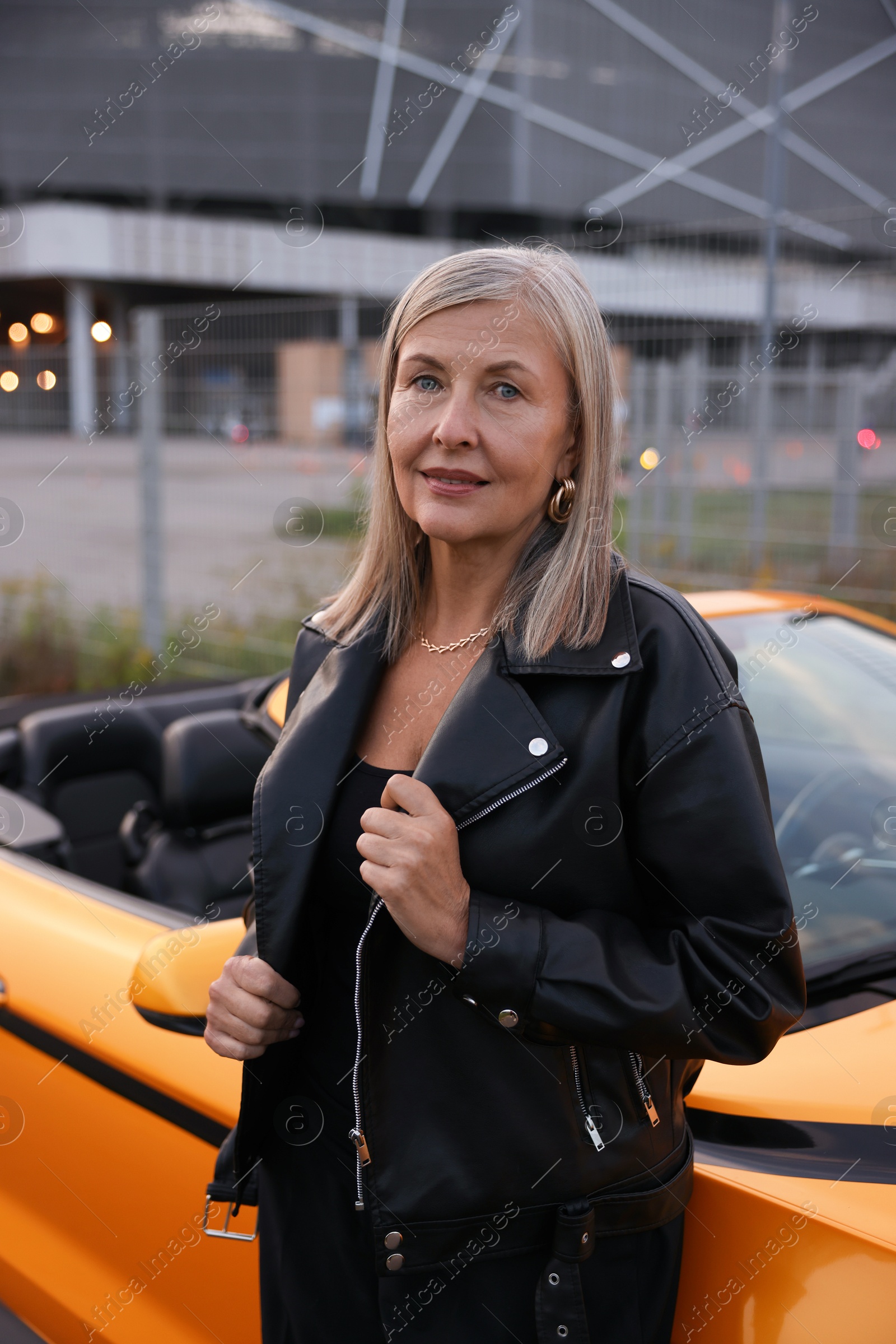 Photo of Stylish senior woman near modern cabriolet outdoors