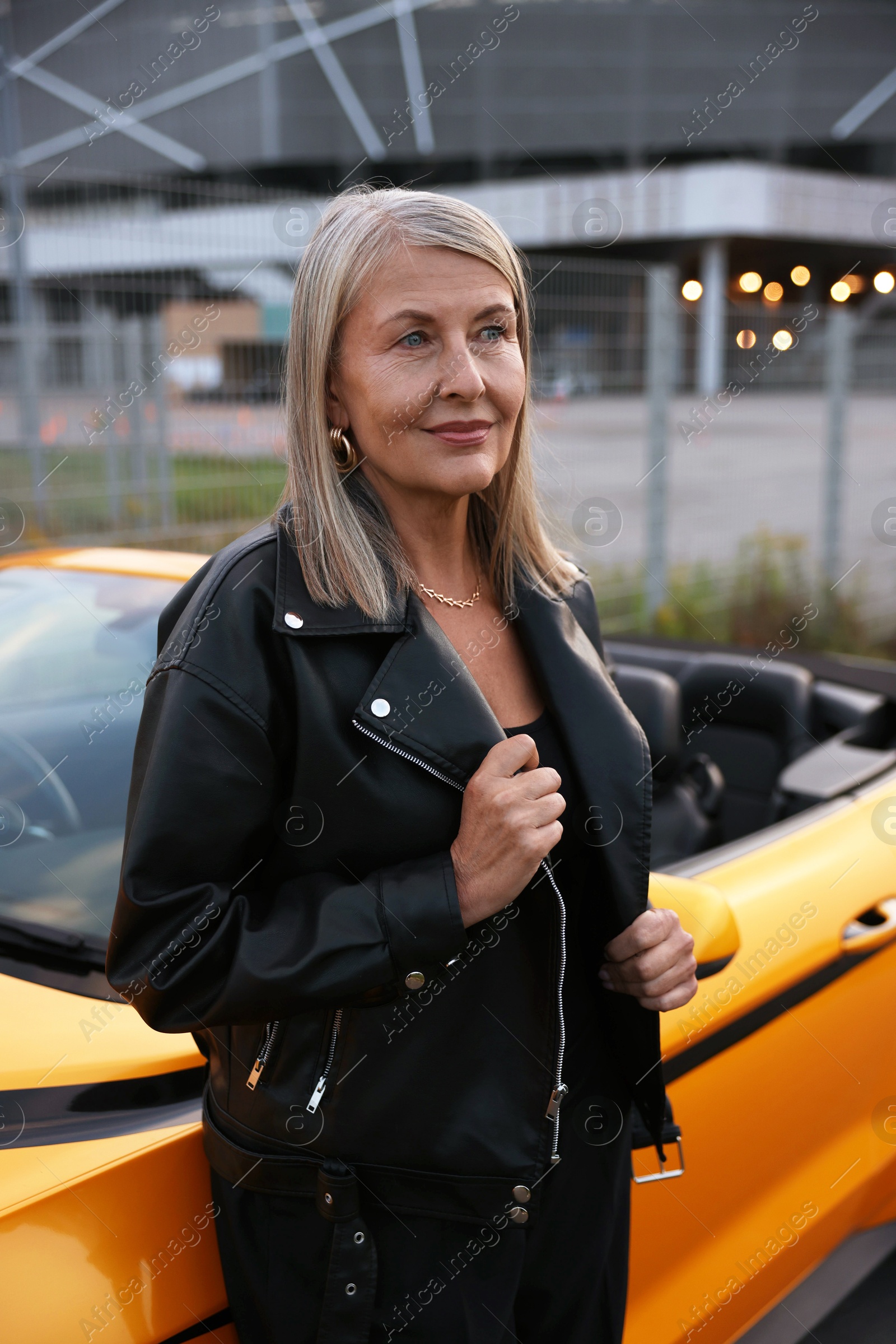 Photo of Stylish senior woman near modern cabriolet outdoors