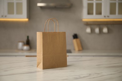 Photo of Paper bag on white marble table in kitchen. Space for text