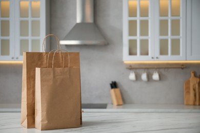 Photo of Paper bags on white marble table in kitchen. Space for text