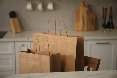 Photo of Paper bags on chair in kitchen, closeup