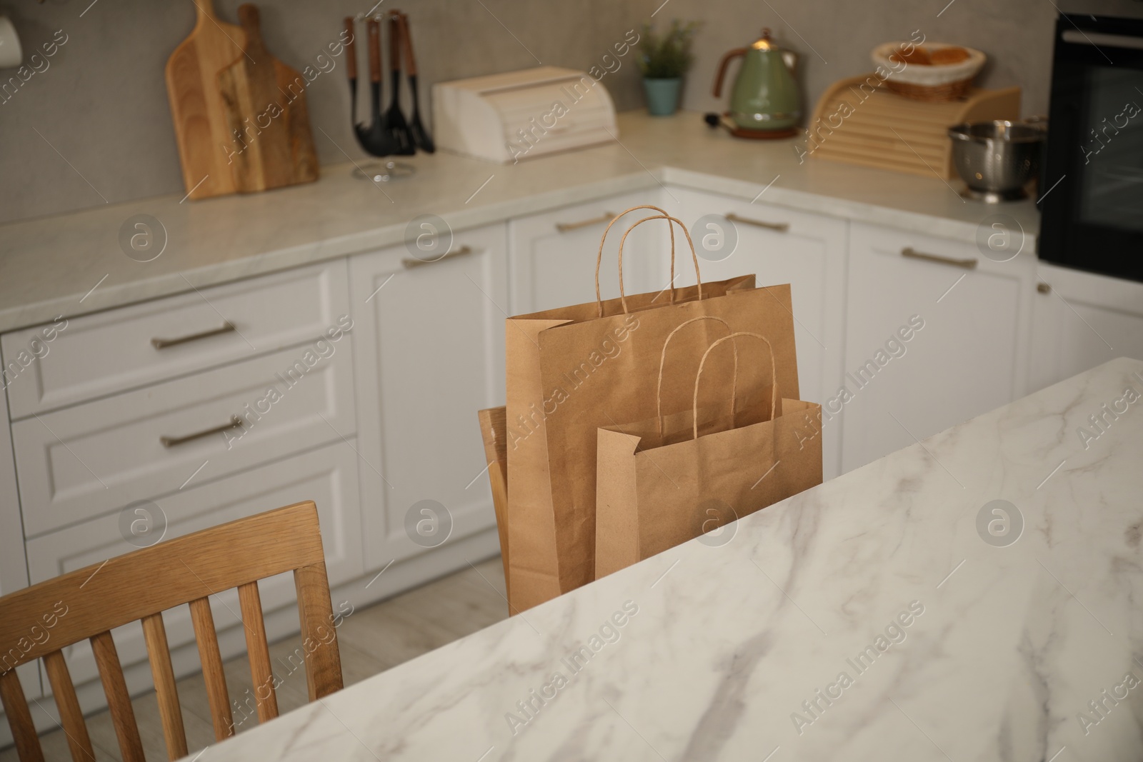 Photo of Paper bags on chair in kitchen, closeup