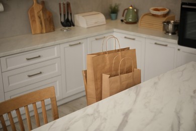 Photo of Paper bags on chair in kitchen, closeup