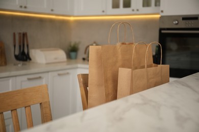 Photo of Paper bags on chair in kitchen, closeup
