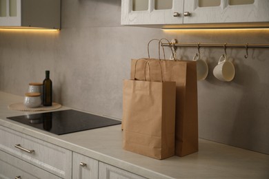 Photo of Paper bags on white counter in kitchen. Space for text