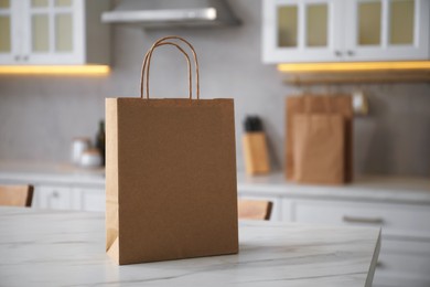 Photo of Paper bag on white marble table in kitchen. Space for text
