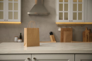Photo of Paper bag on white marble table in kitchen. Space for text