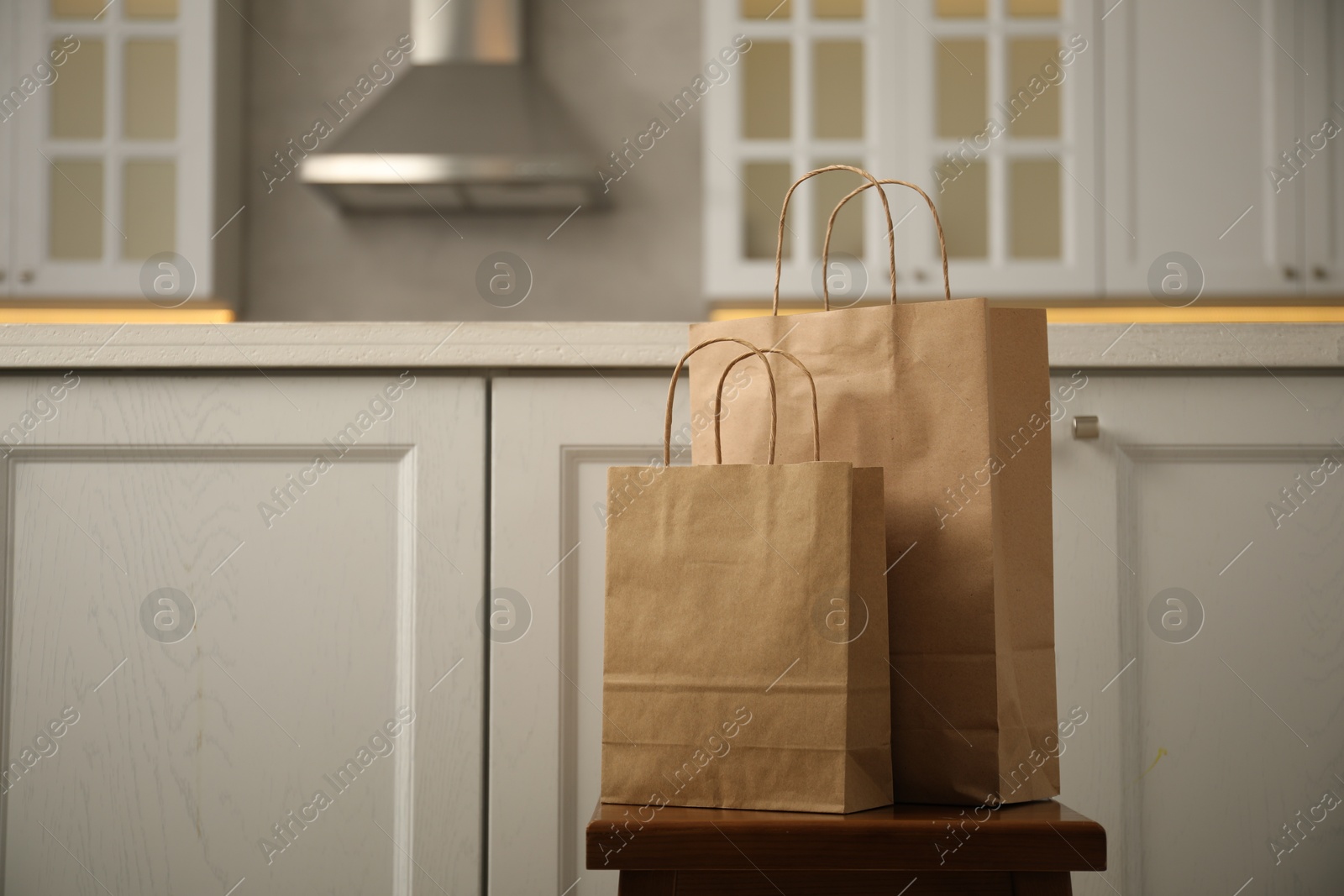 Photo of Paper bags on stool in kitchen. Space for text