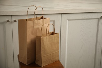 Photo of Paper bags on stool in kitchen. Space for text