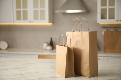 Photo of Paper bags on white marble table in kitchen. Space for text