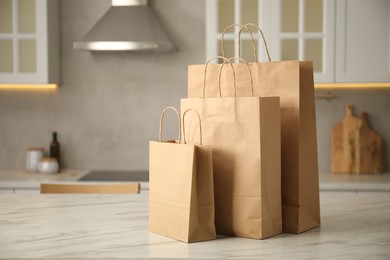 Photo of Paper bags on white marble table in kitchen. Space for text