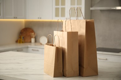 Photo of Paper bags on white marble table in kitchen. Space for text