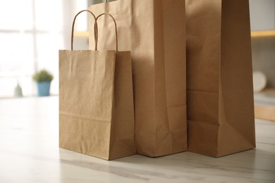 Photo of Paper bags on white marble table in kitchen, closeup