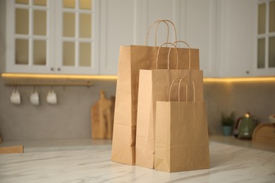 Photo of Paper bags on white marble table in kitchen. Space for text