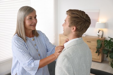 Photo of Smiling mother taking care of her son at home. Family bonding