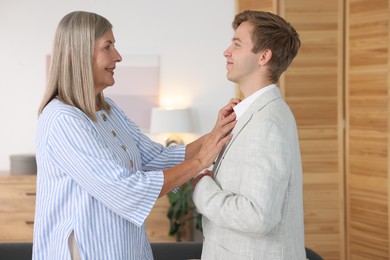 Photo of Smiling mother taking care of her son at home. Family bonding
