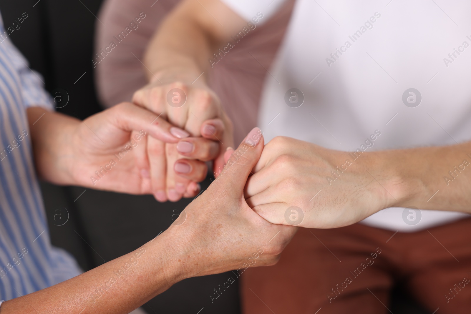 Photo of Son and his mother holding hands indoors, closeup