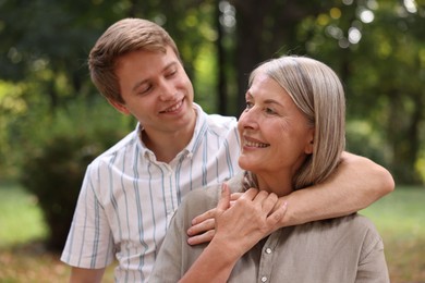 Photo of Smiling mother and her son in park. Family bonding