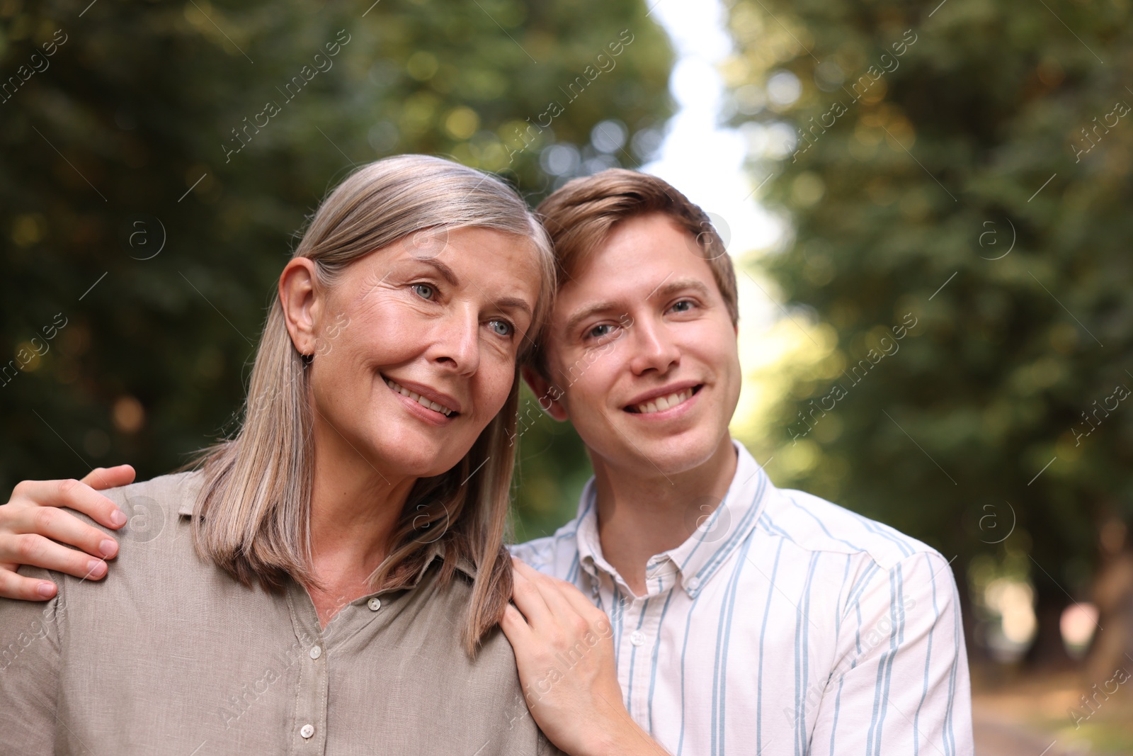 Photo of Smiling mother and her son outdoors. Family bonding