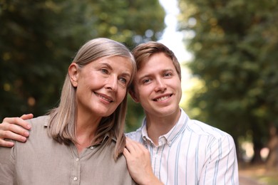 Photo of Smiling mother and her son outdoors. Family bonding
