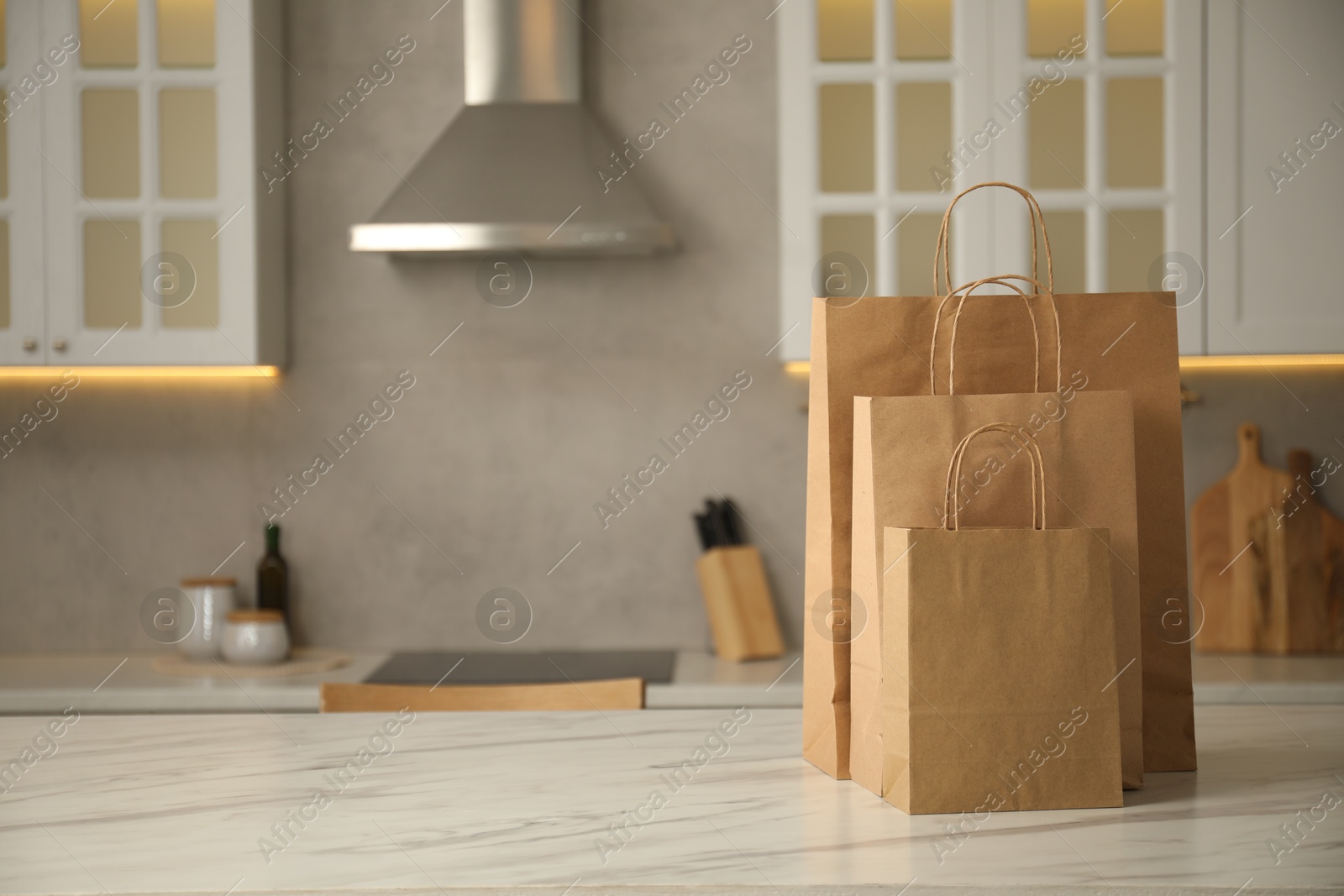 Photo of Paper bags on white marble table in kitchen. Space for text