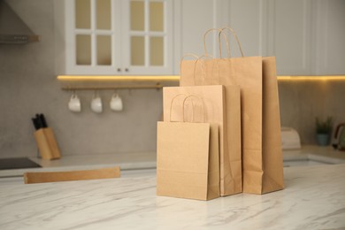 Photo of Paper bags on white marble table in kitchen. Space for text