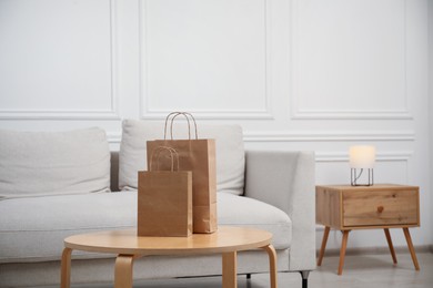 Photo of Paper bags on wooden table at home. Space for text